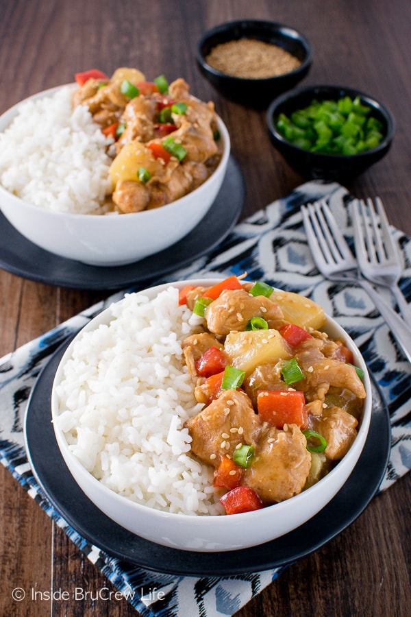 Two white bowls filled with rice and sweet and sour chicken