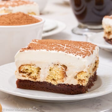 A white plate with a brownie square topped with coffee filling.