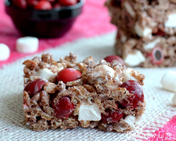 A square photo with an up close shot of the Cherry Marshmallow Rice Krispie Treats on white burlap