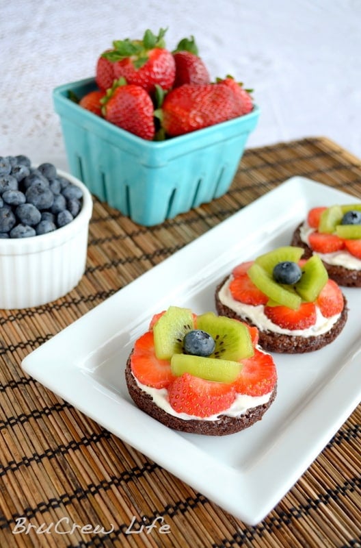 These mini brownies are topped with frosting and fresh fruit to look like flowers. So cute for parties!