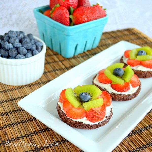 These mini brownies are topped with frosting and fresh fruit to look like flowers. So cute for parties!