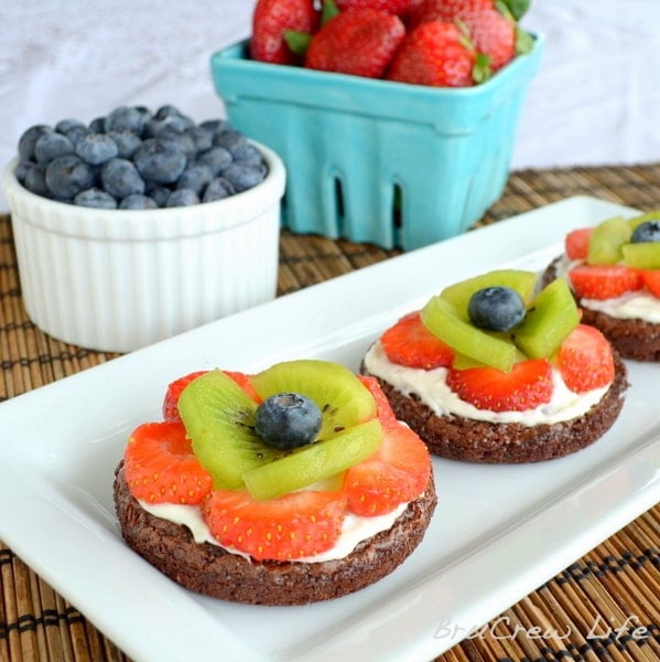 These mini brownies are topped with frosting and fresh fruit to look like flowers. So cute for parties!