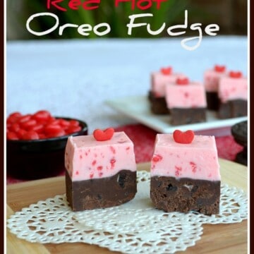 A white doily with two squares of red hot oreo fudge showing the two layers of each flavor in each piece