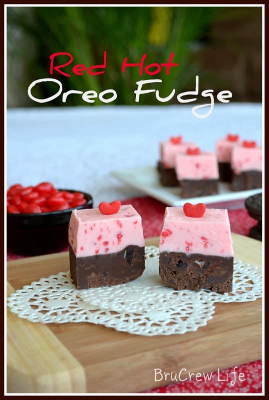 Two pieces of red hot Oreo fudge on a white doily showing the two layers of different fudge in each piece