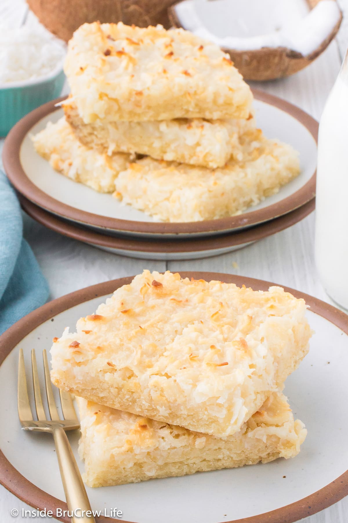 Two coconut bars stacked on a plate.