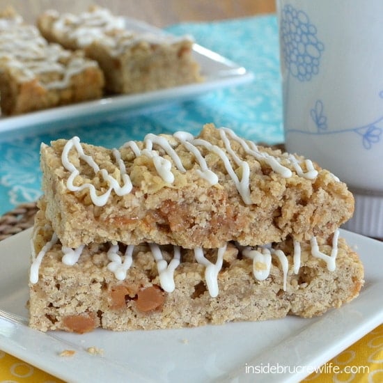 A white plate with two caramel oatmeal bars drizzled with white chocolate stacked together