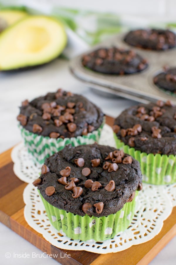 Three chocolate muffins made with avocado on a wooden board