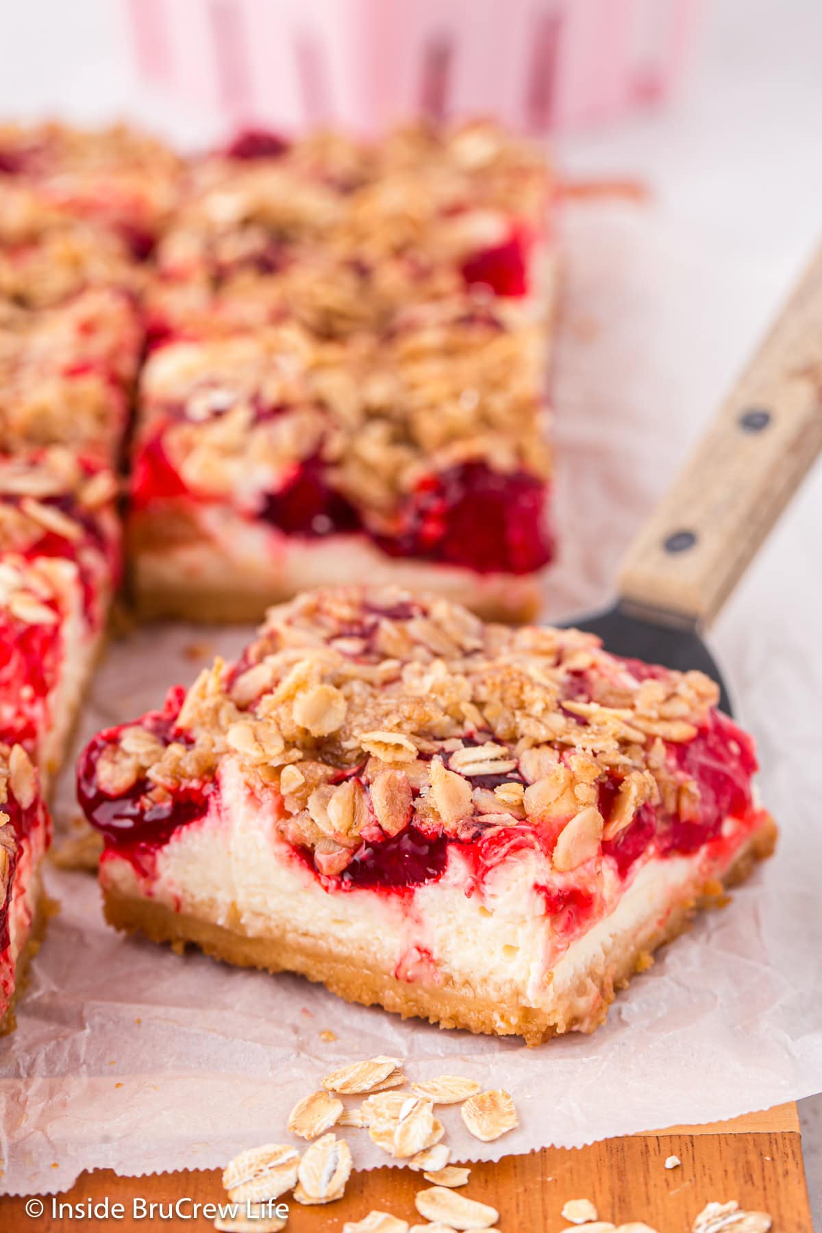 Cheesecake bars topped with strawberry filling and a crumble topping.