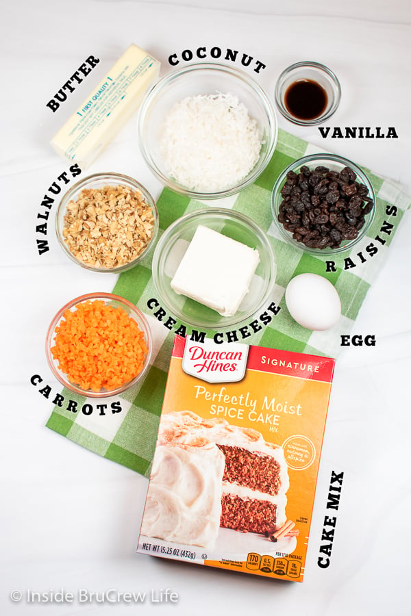 A white board with bowls of ingredients to make carrot cookies.