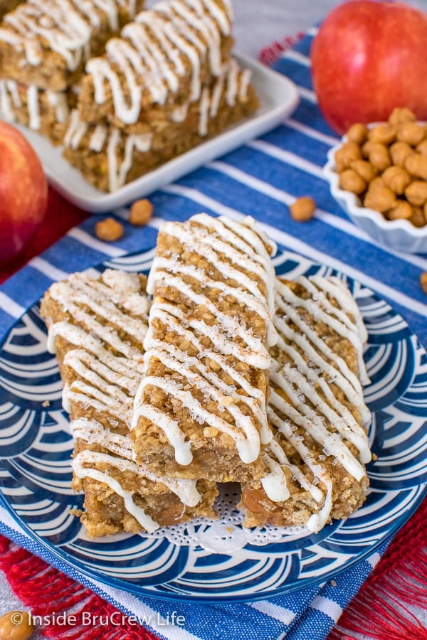 A blue plate with three homemade  granola bars stacked on it.