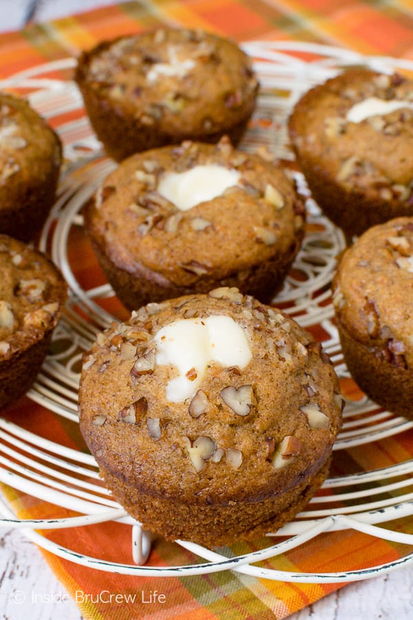 A white wire tray with carrot cheesecake muffins on it.