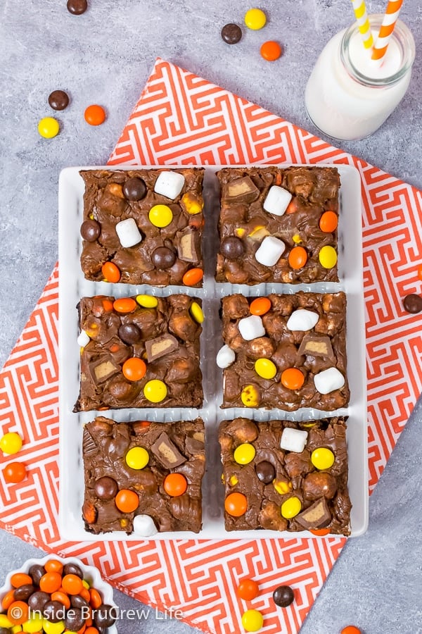 Overhead picture of a white tray with six Reese's Fluffernutter Fudge Brownies and a bowl of Reese's candies beside it