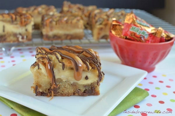 Cheesecake cookie bars loaded with Milky Way candy bars and caramel drizzles make the best kind of dessert!