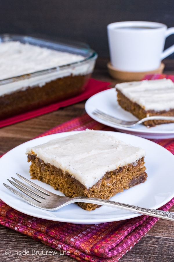 Two white plates with squares of glazed apple butter cake on them.