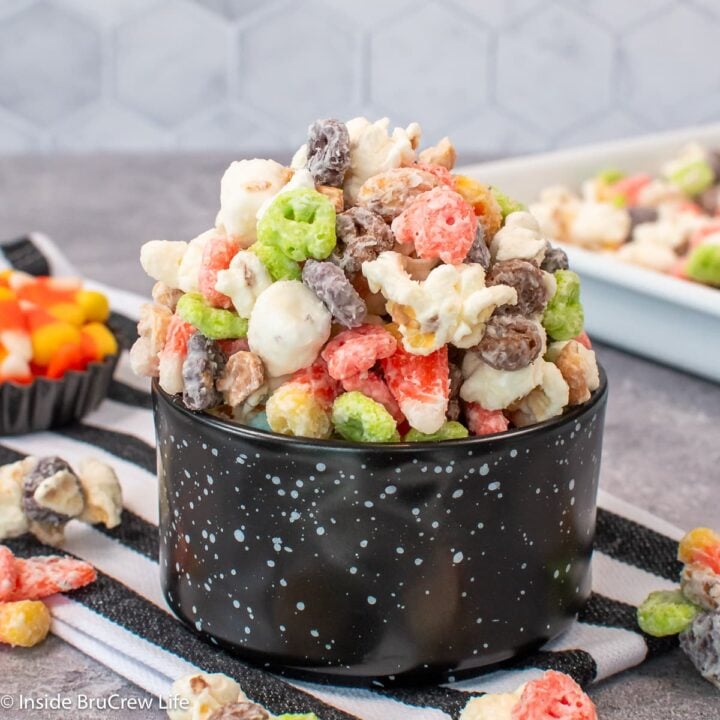 A black bowl filled with a Halloween popcorn mix.