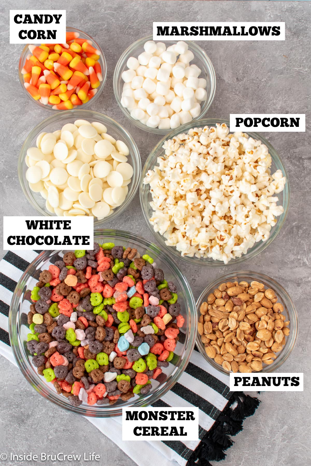 Bowls of ingredients needed to make a popcorn mix.