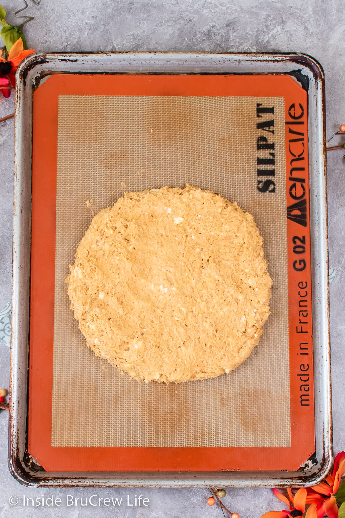 A sheet pan with a circle of scone dough.