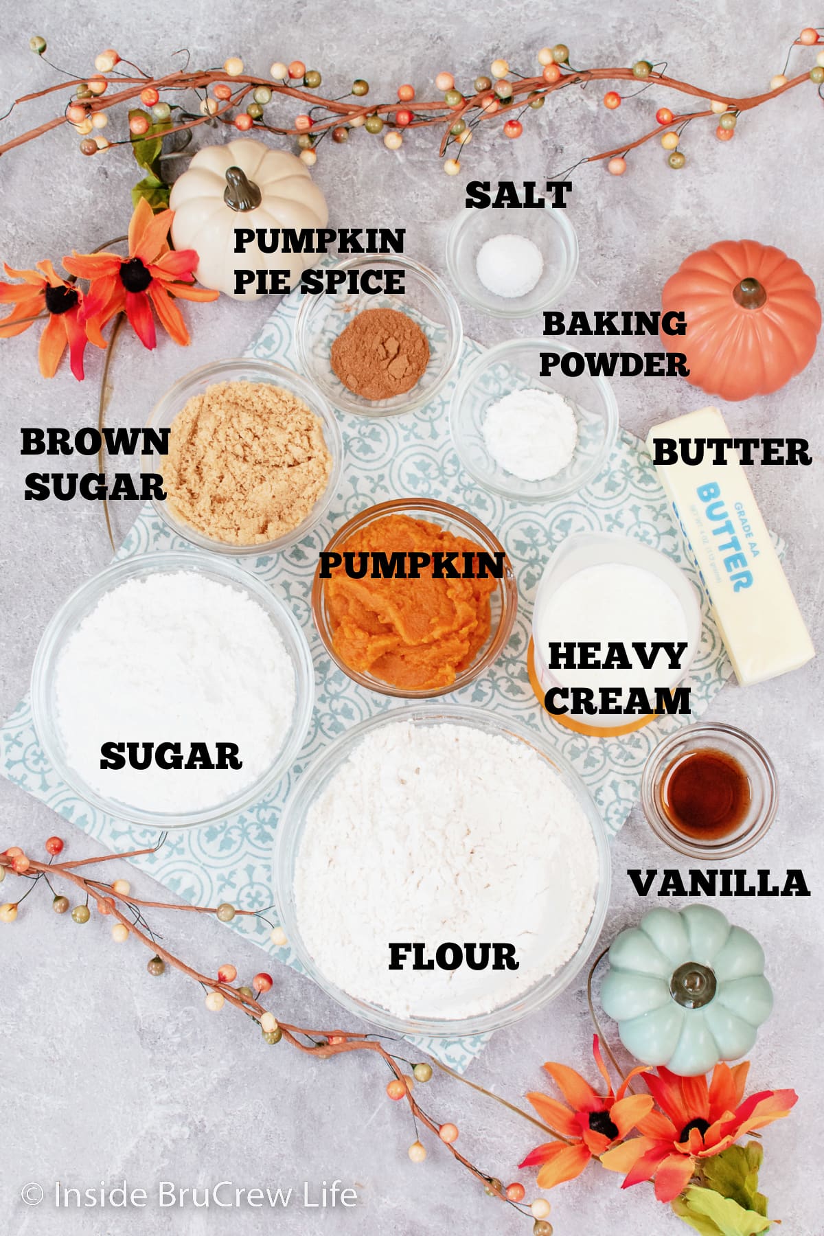 A white board with bowls of ingredients needed for pumpkin scones.
