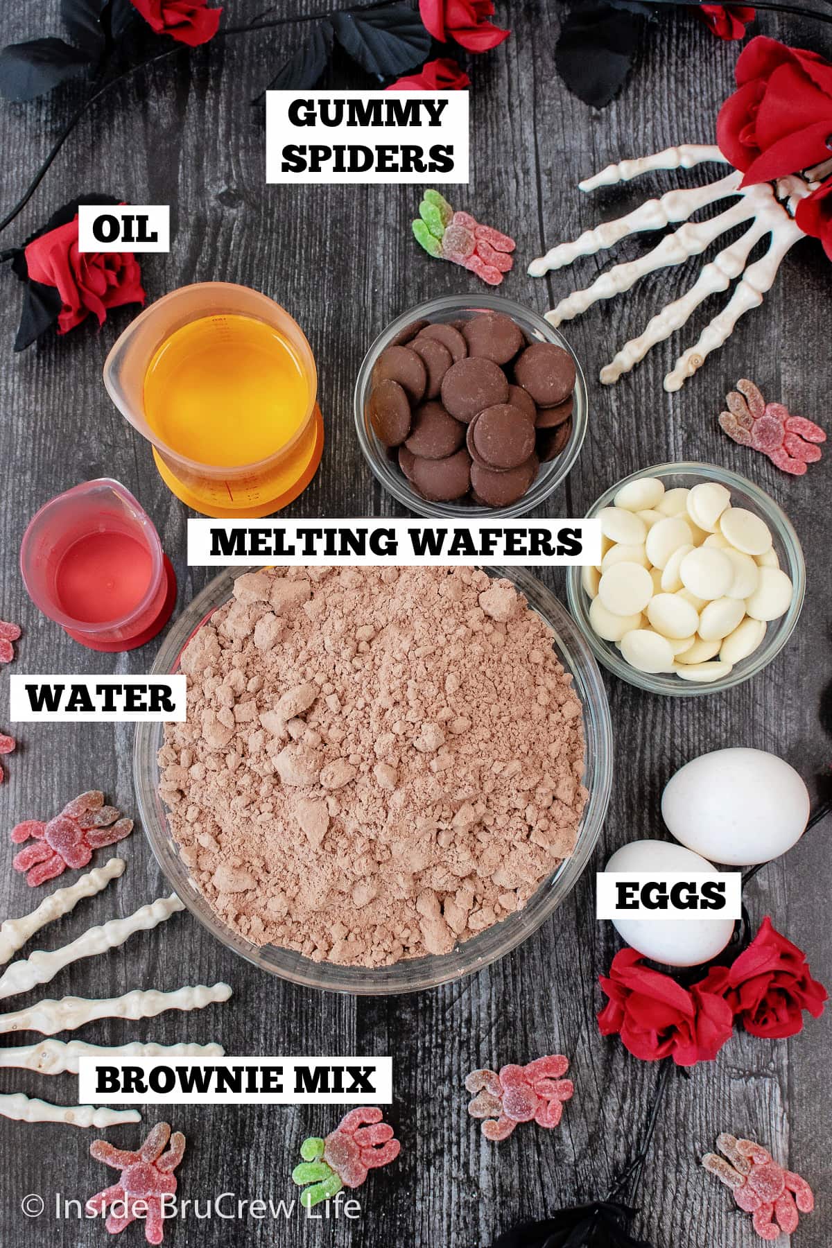 A dark board with bowls of ingredients needed to make Halloween brownies.