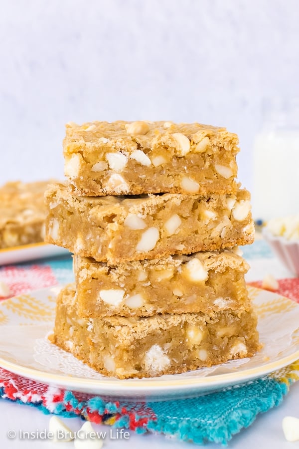 A stack of four tropical blonde brownies on a white and yellow plate