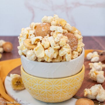 Chocolate covered popcorn in a bowl with cookies and dried bananas.