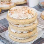 A stack of four churro cookies topped with cinnamon frosting and cinnamon sugar.