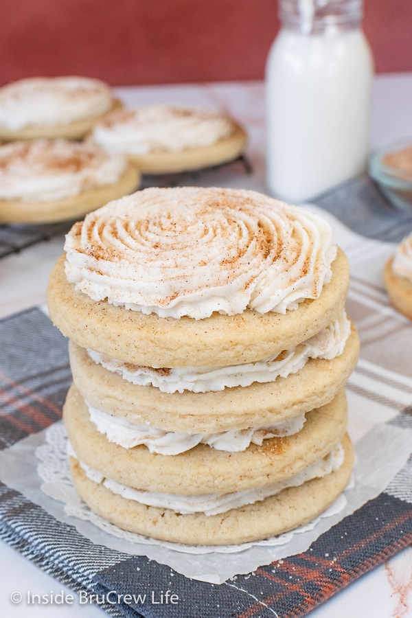 A stack of four churro cookies with cinnamon frosting and cinnamon sugar.