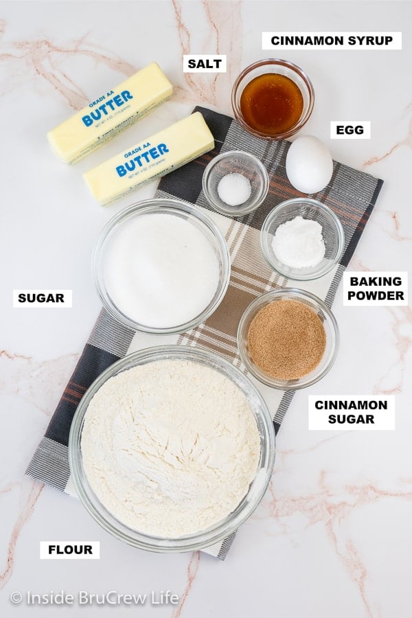 A white board with bowls of ingredients needed to make churro sugar cookies.