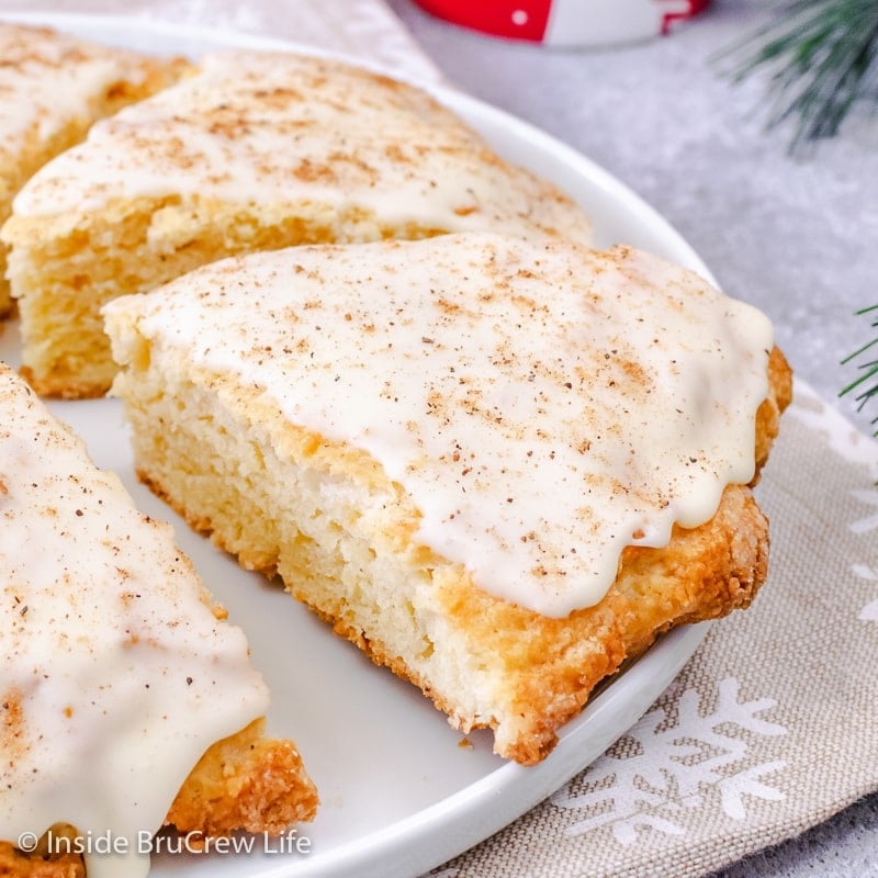 A white plate with glazed eggnog scones on it.
