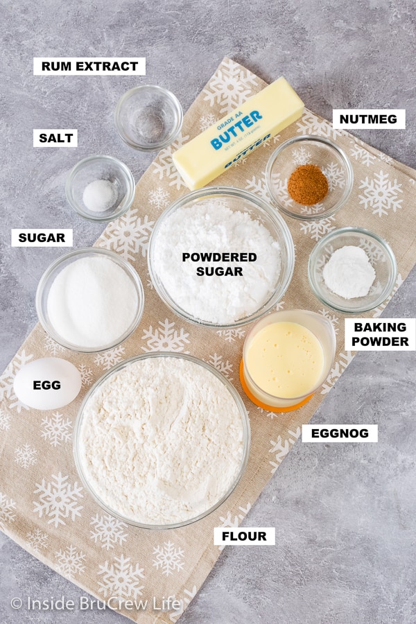 Overhead picture of a gray board with bowls of ingredients needed to make eggnog scones.