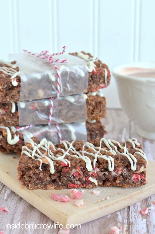 A stack of peppermint hot chocolate granola bars wrapped in parchment and string on a wood tray