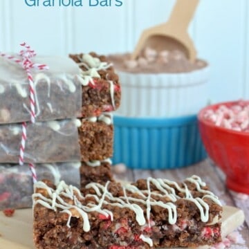 Peppermint Hot Chocolate Granola Bars stacked on a wood tray with one out in front