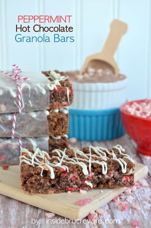 A stack of peppermint hot chocolate granola bars on a wood tray with one out in front