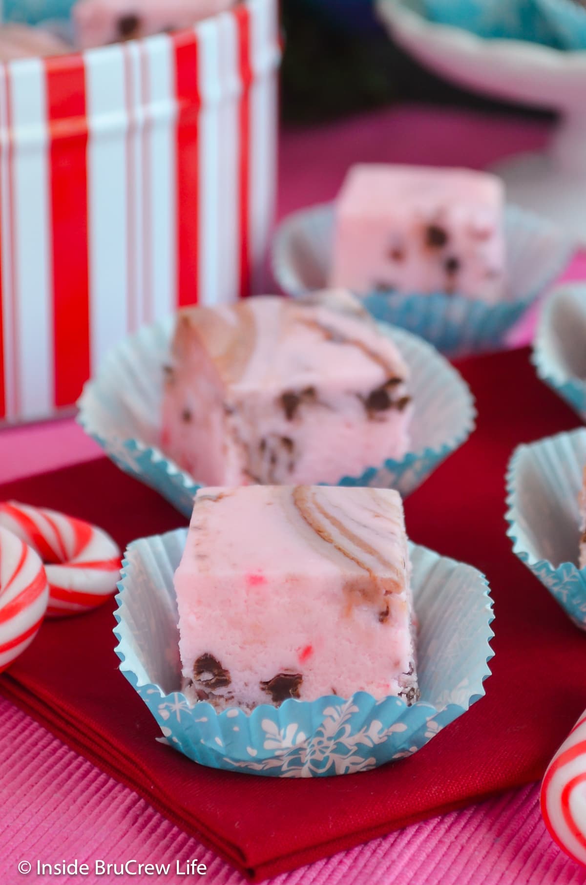 Pink swirled fudge squares on a red towel.