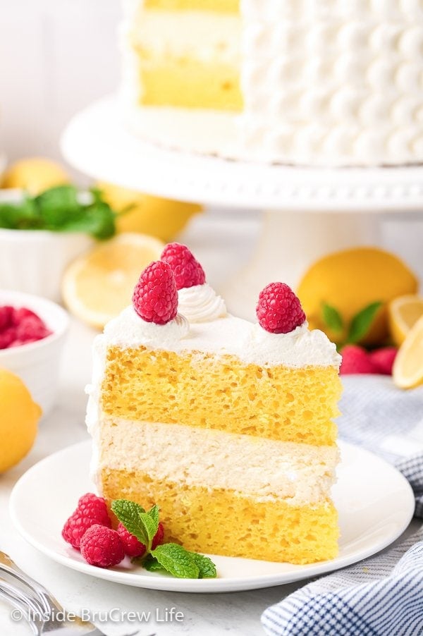 A white plate with a slice of lemon cake on it.