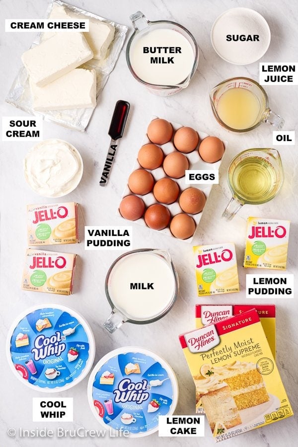 A white board with bowls of ingredients needed to make lemon cake and pudding frosting.
