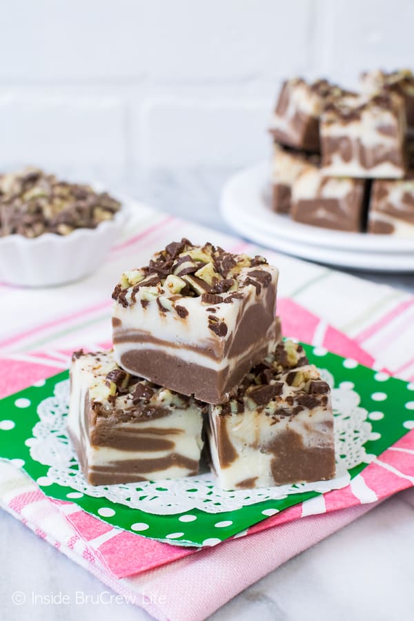 3 pieces of MInt Brownie Swirl Fudge on a white doily, green napkin, and pink towel.