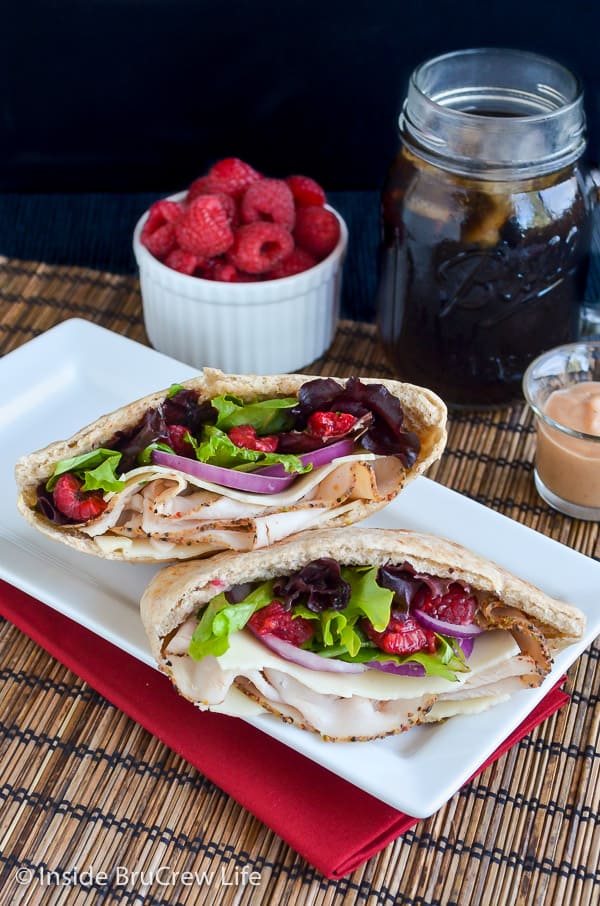 Overhead picture of two pita halves filled with turkey, salad, and raspberries