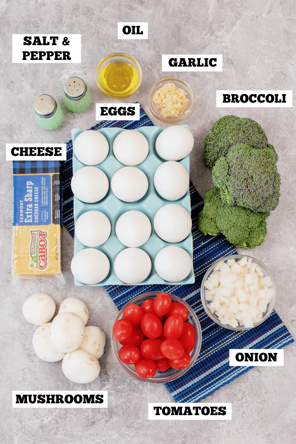 A gray board with bowls of ingredients needed to make a broccoli and egg casserole.