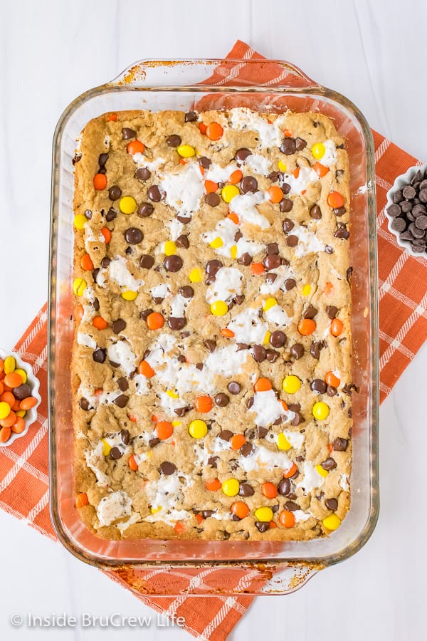 Overhead picture of a pan of Marshmallow Reese's Blonde Brownies on a white background and orange towel