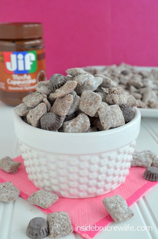 A white bowl filled with puppy chow and chocolate espresso candies.