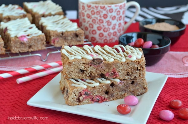 Two Raspberry Hot Chocolate Granola Bars on a white plate with more bars behind it.