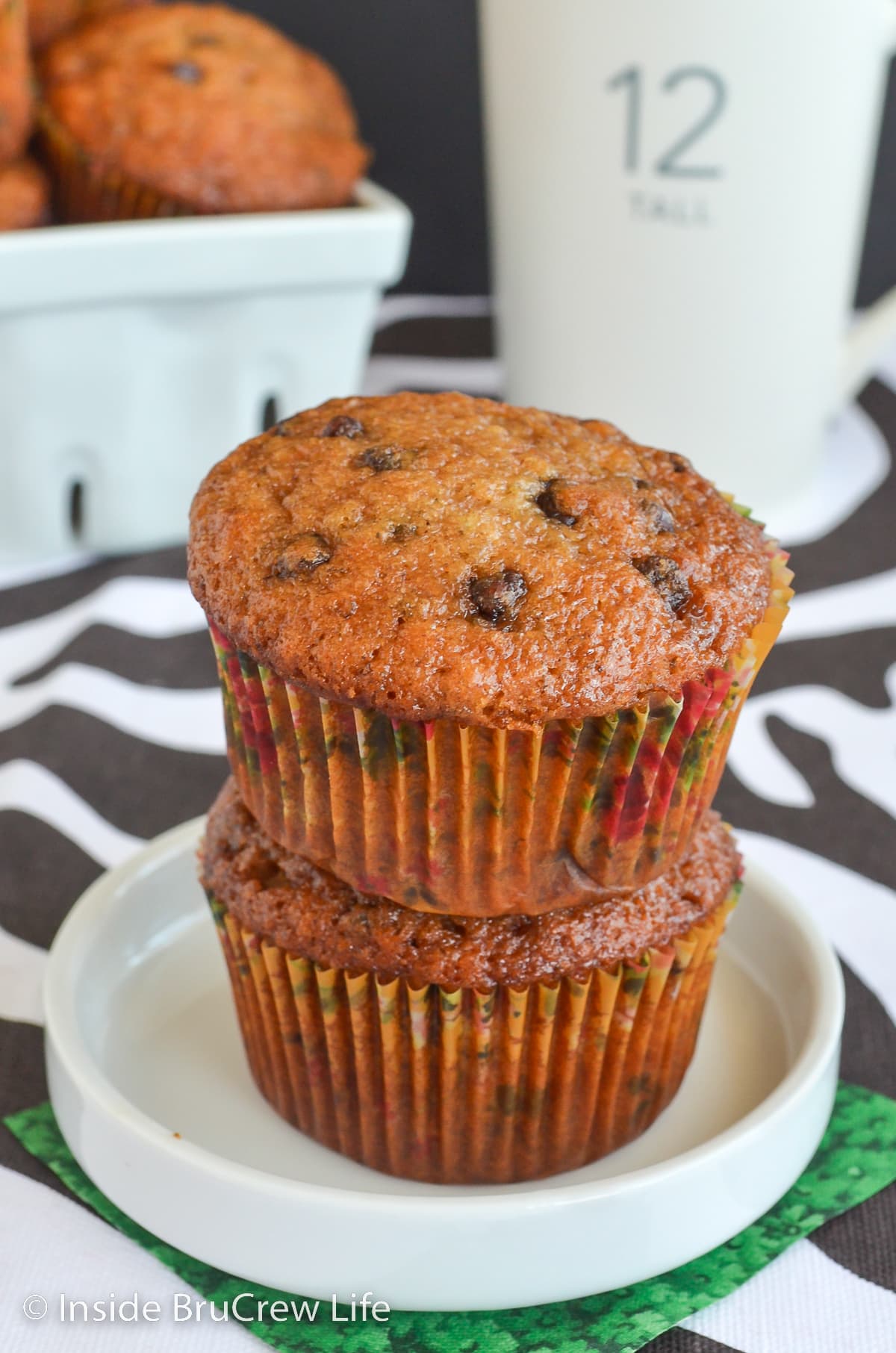 Two banana muffins stacked on a plate.