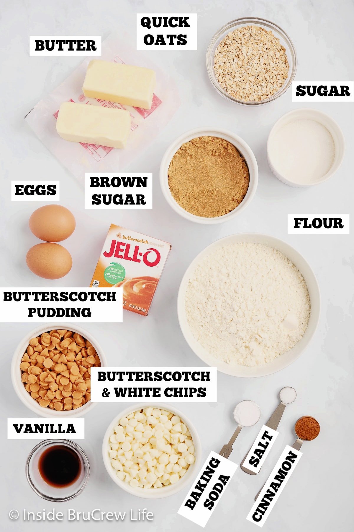A white board with bowls of ingredients needed to make butterscotch pudding cookies.