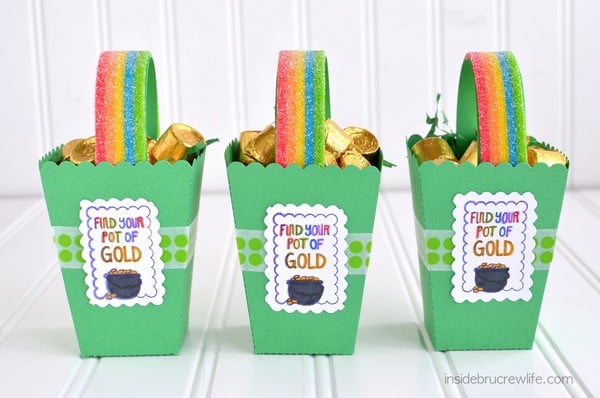 Three green St. Patrick's Day boxes lined up and filled with Rolos and rainbow candy handles