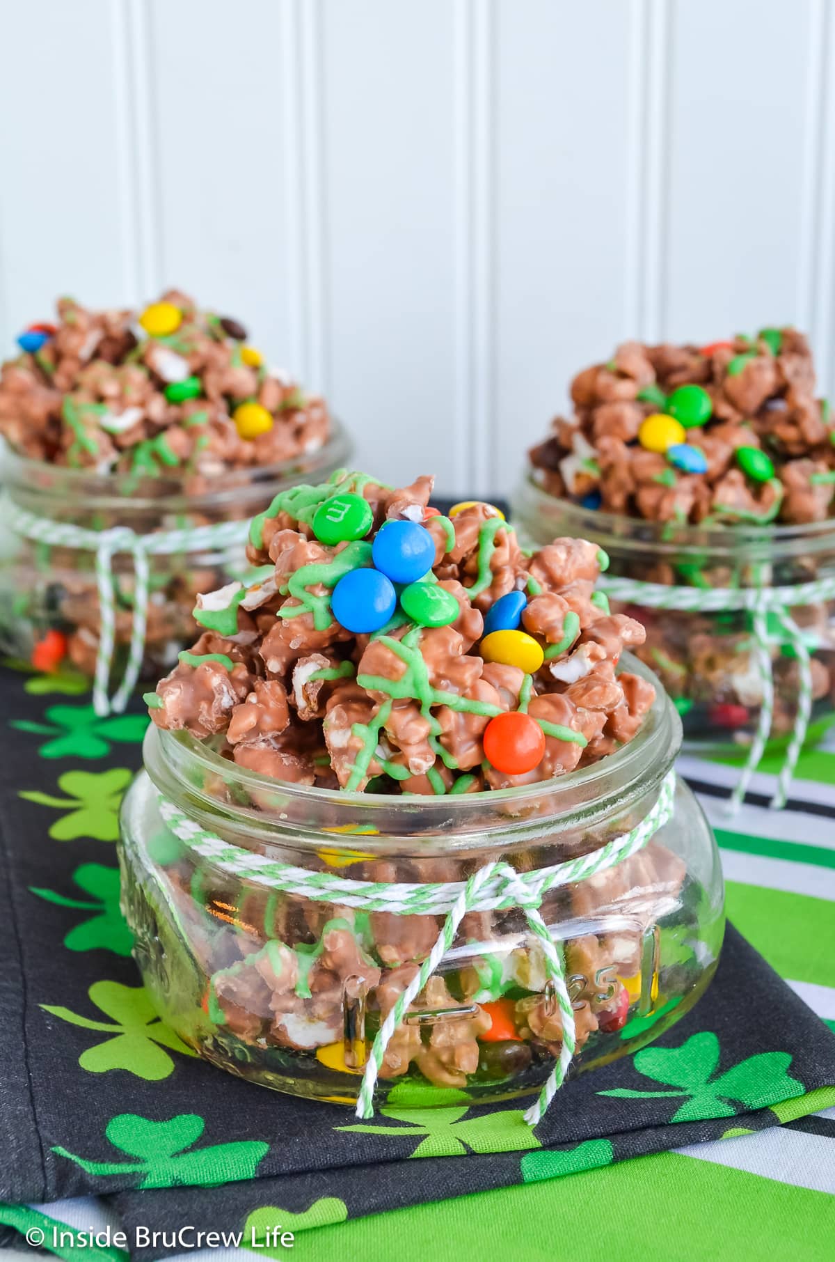 Three jars filled with chocolate covered popcorn.
