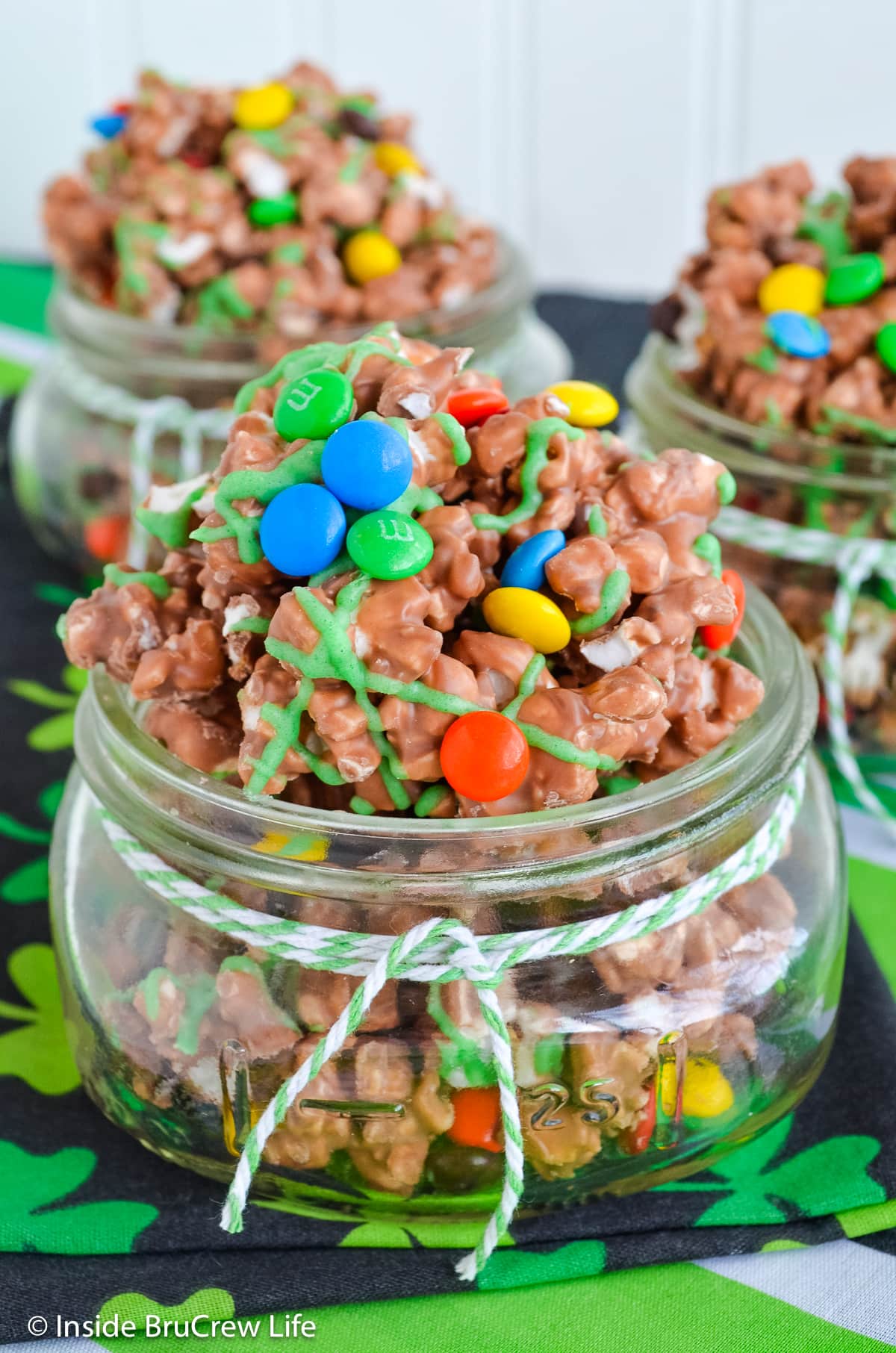 Jars filled with chocolate popcorn and candy.
