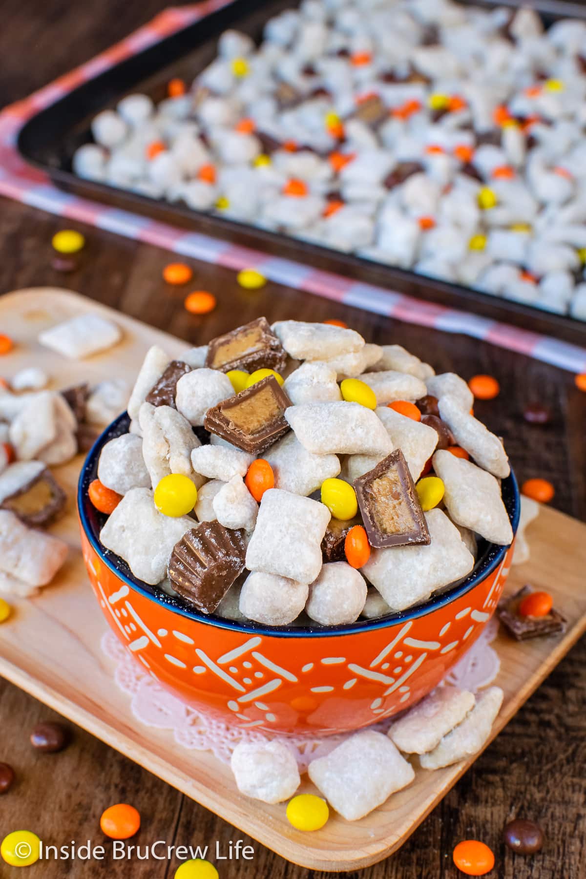 An orange bowl full of peanut butter muddy buddies.