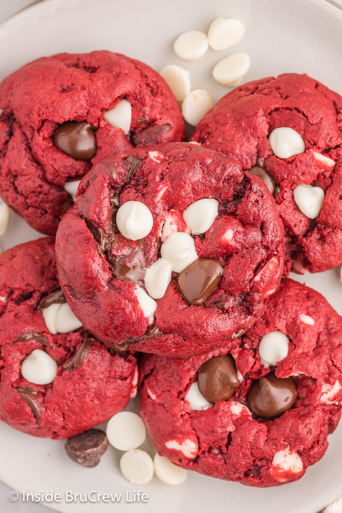 A pile of red velvet cookies with chocolate chips on a plate.