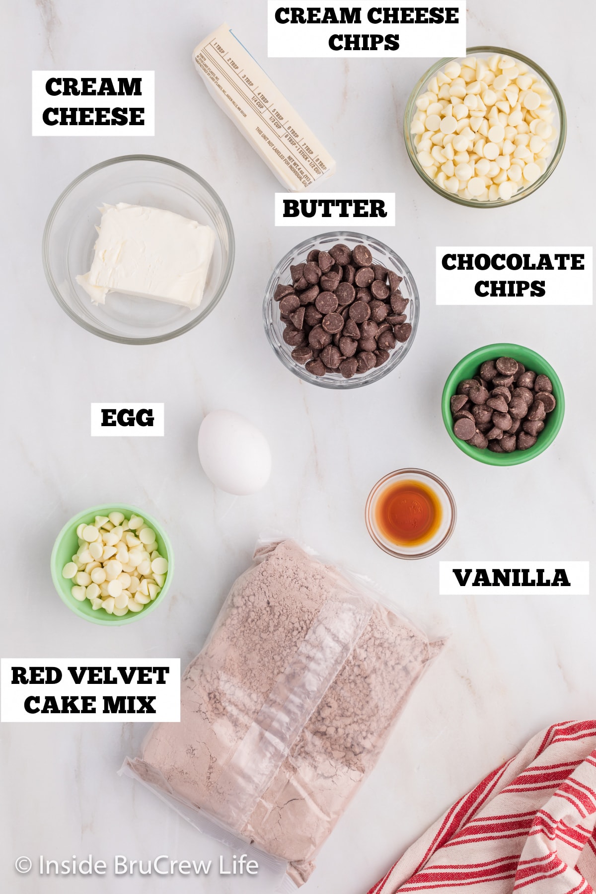 A white board with bowls of ingredients needed to make cake mix cookies.